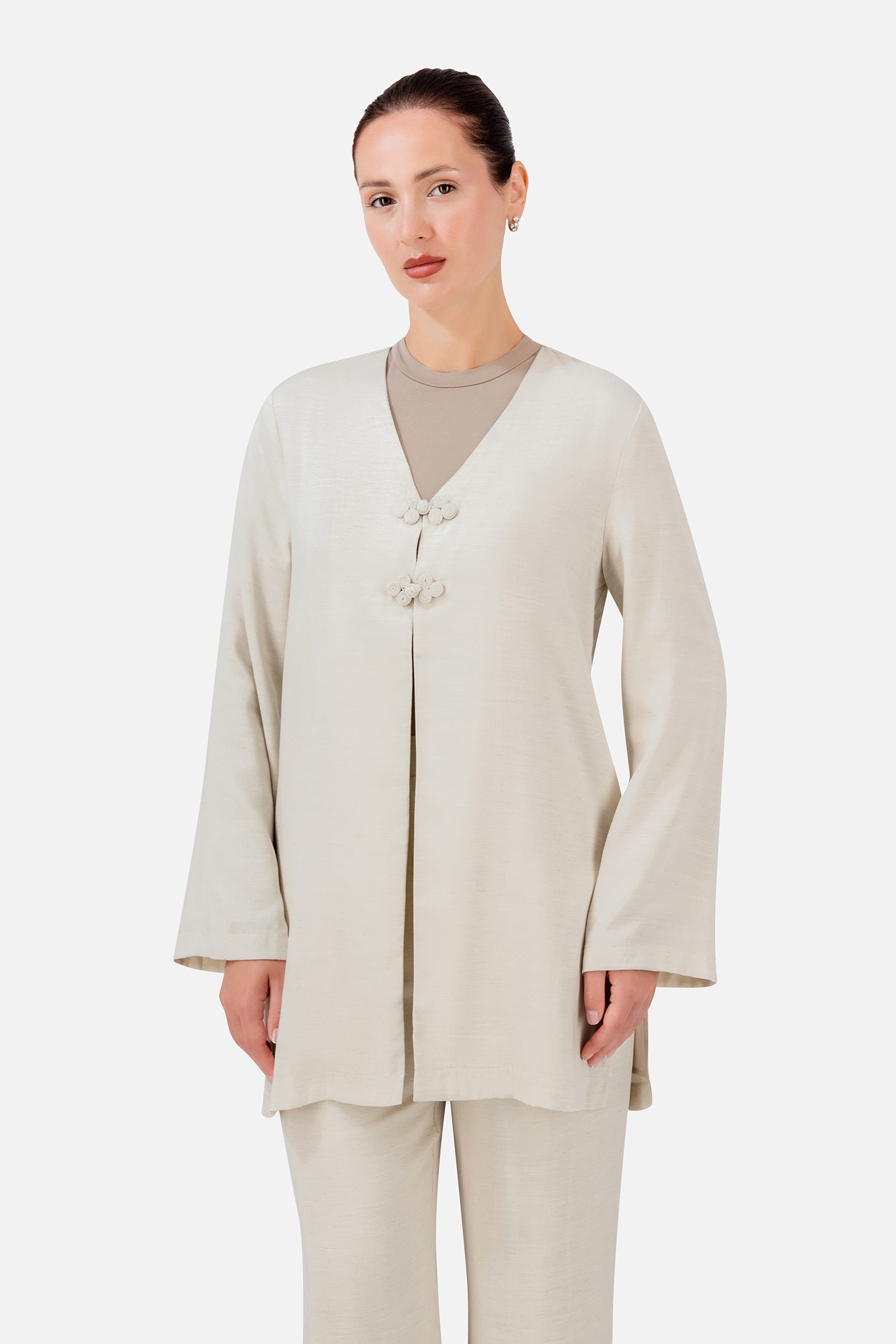FARES Knot Detail Cardigan in Bare shown at an angle, highlighting the knot closures and easy longline shape.