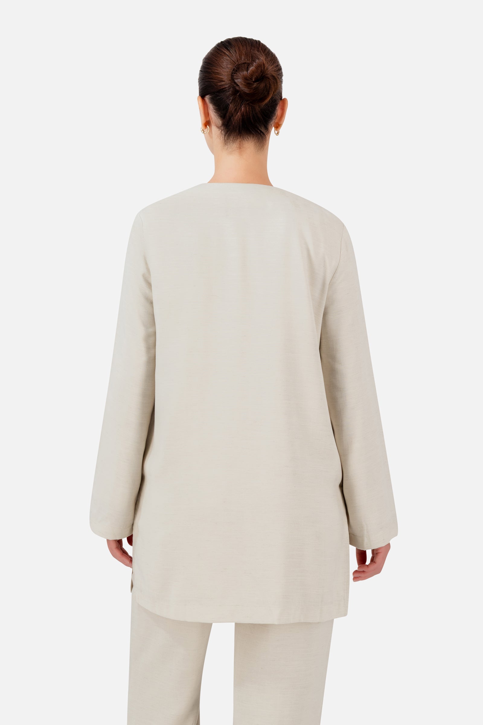 FARES Knot Detail Cardigan in Bare shown from the back, highlighting the clean longline shape and relaxed wide sleeves.