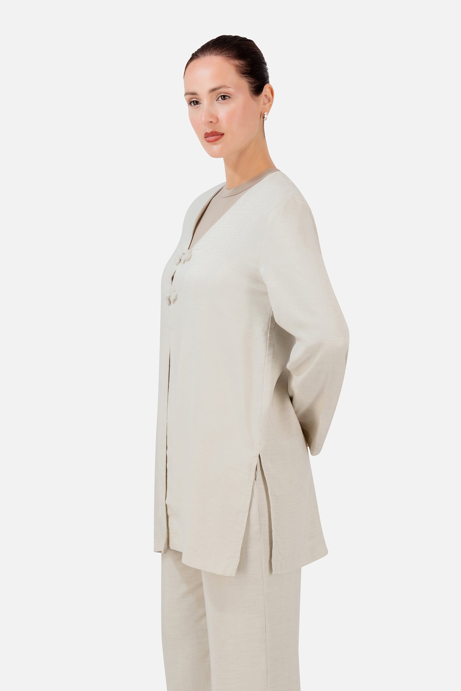 FARES Knot Detail Cardigan in Bare shown from the side, featuring the softly structured silhouette and flowing wide-sleeve cardigan design.