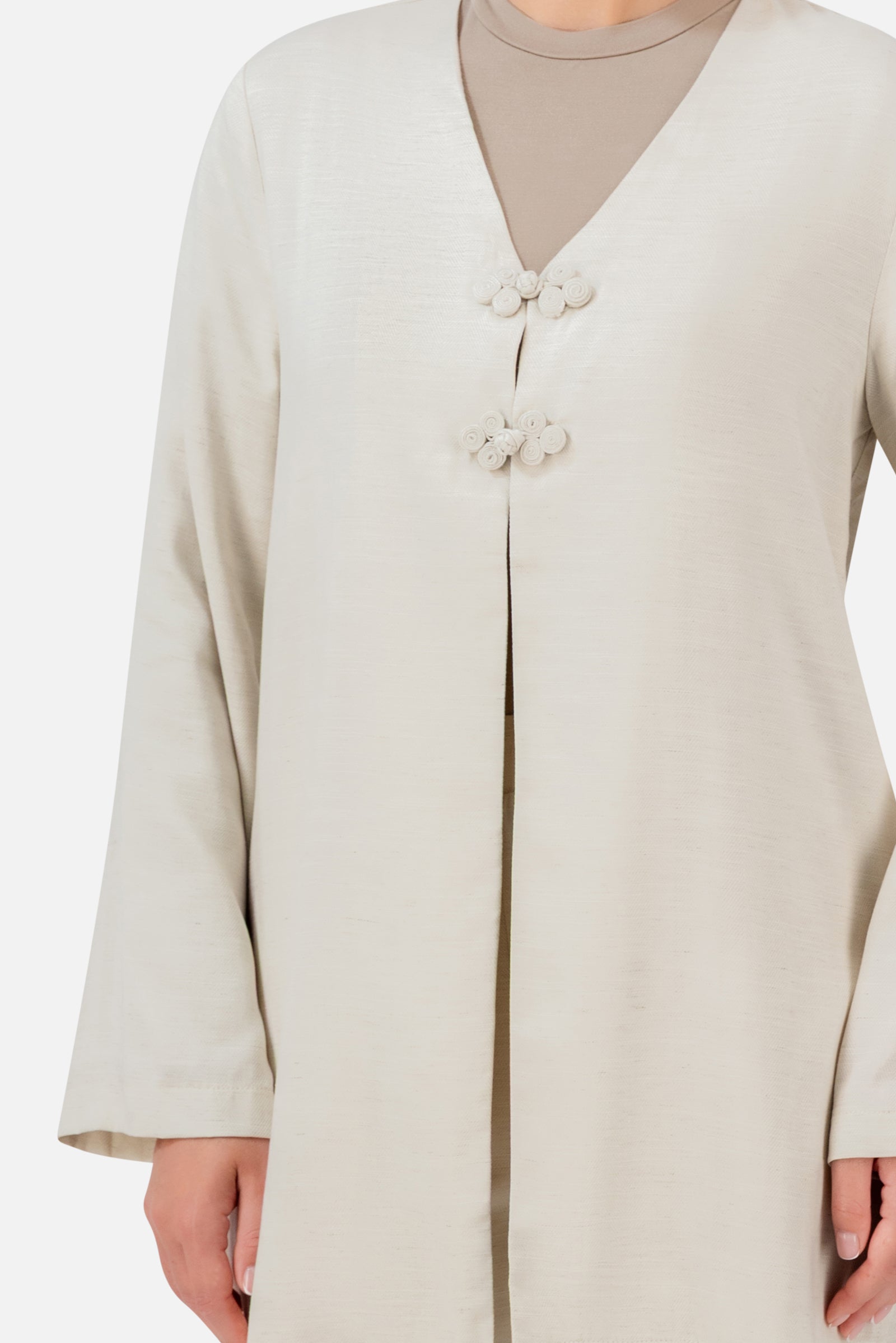 Closer view of the FARES Knot Detail Cardigan in Bare, highlighting the statement knot closures, V-neckline and flowing wide sleeves.