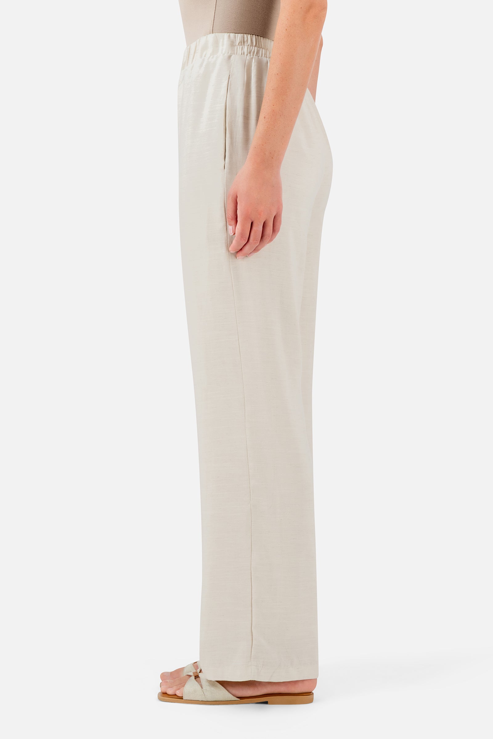 FARES Relaxed Fit Pants in Bare shown from the side, featuring a loose full-length shape and lightweight drape for easy everyday wear.