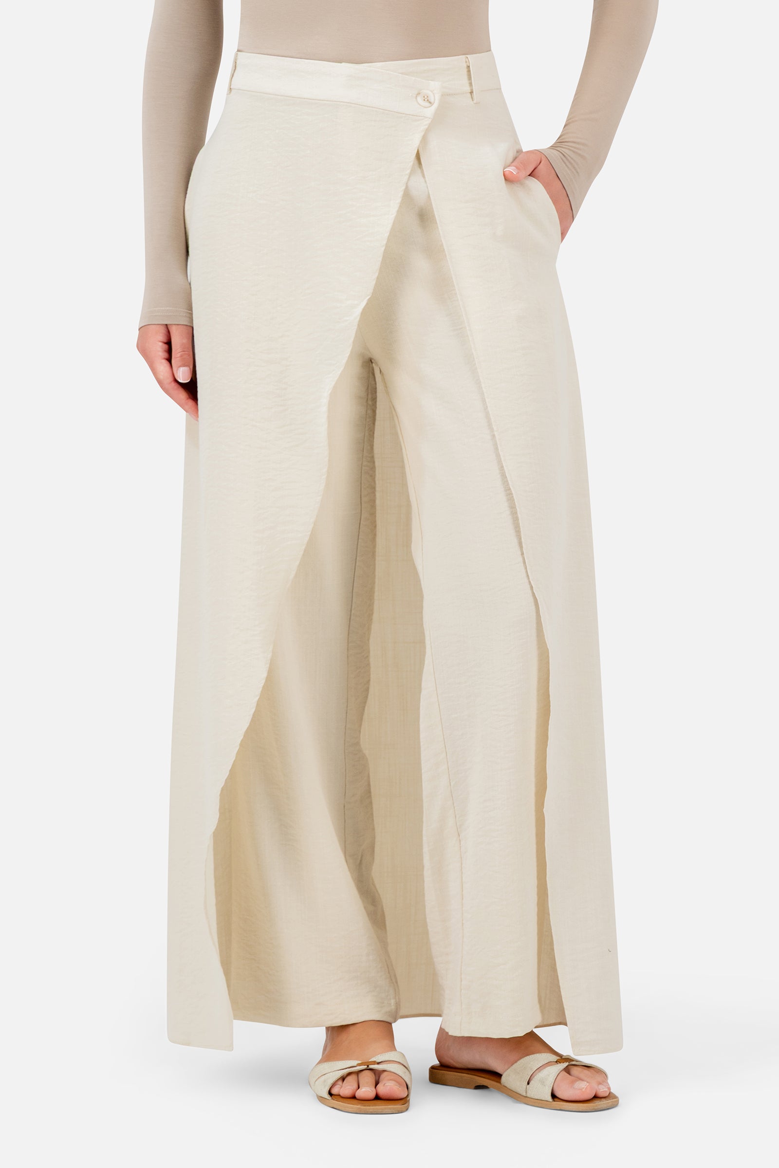 FARES Skirt Overlay Trousers in Oats shown at an angle, highlighting the asymmetric overlay and relaxed wide-leg shape.