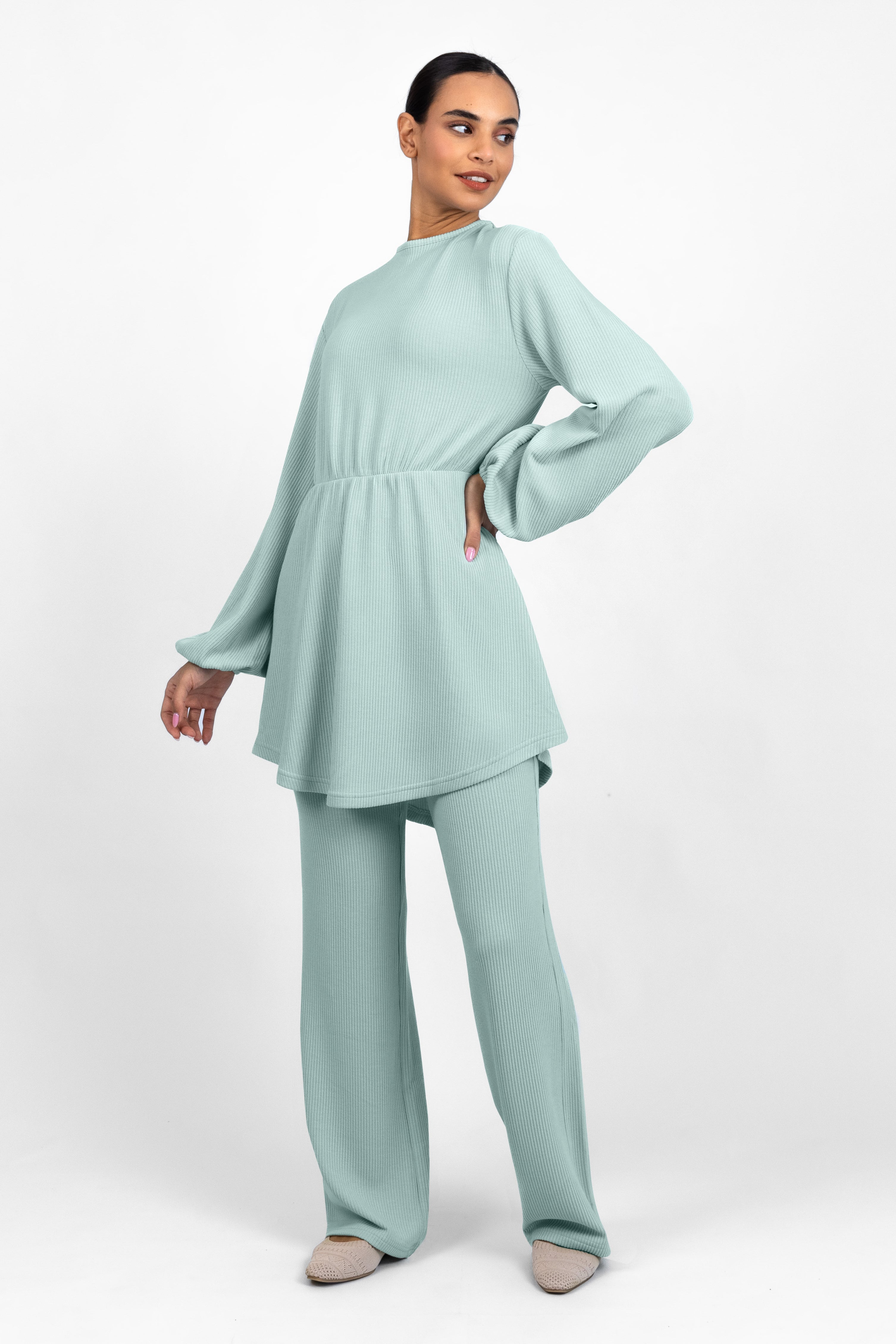 A model is wearing a Knit Peplum Top and looking to the right. Colour: Icy: Blue