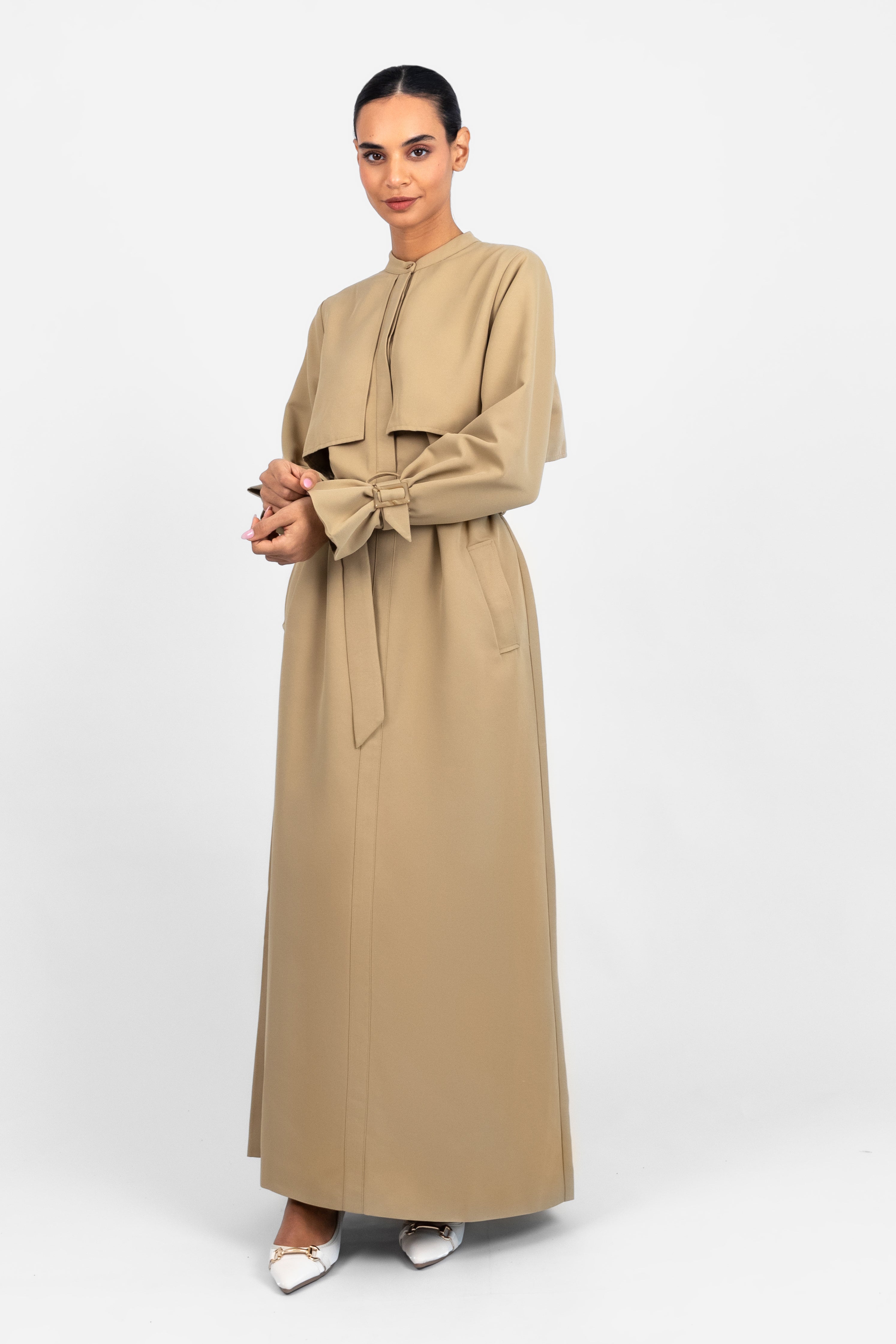 Colour: Tan. A woman standing in a Trench Coat Dress looking to the right.