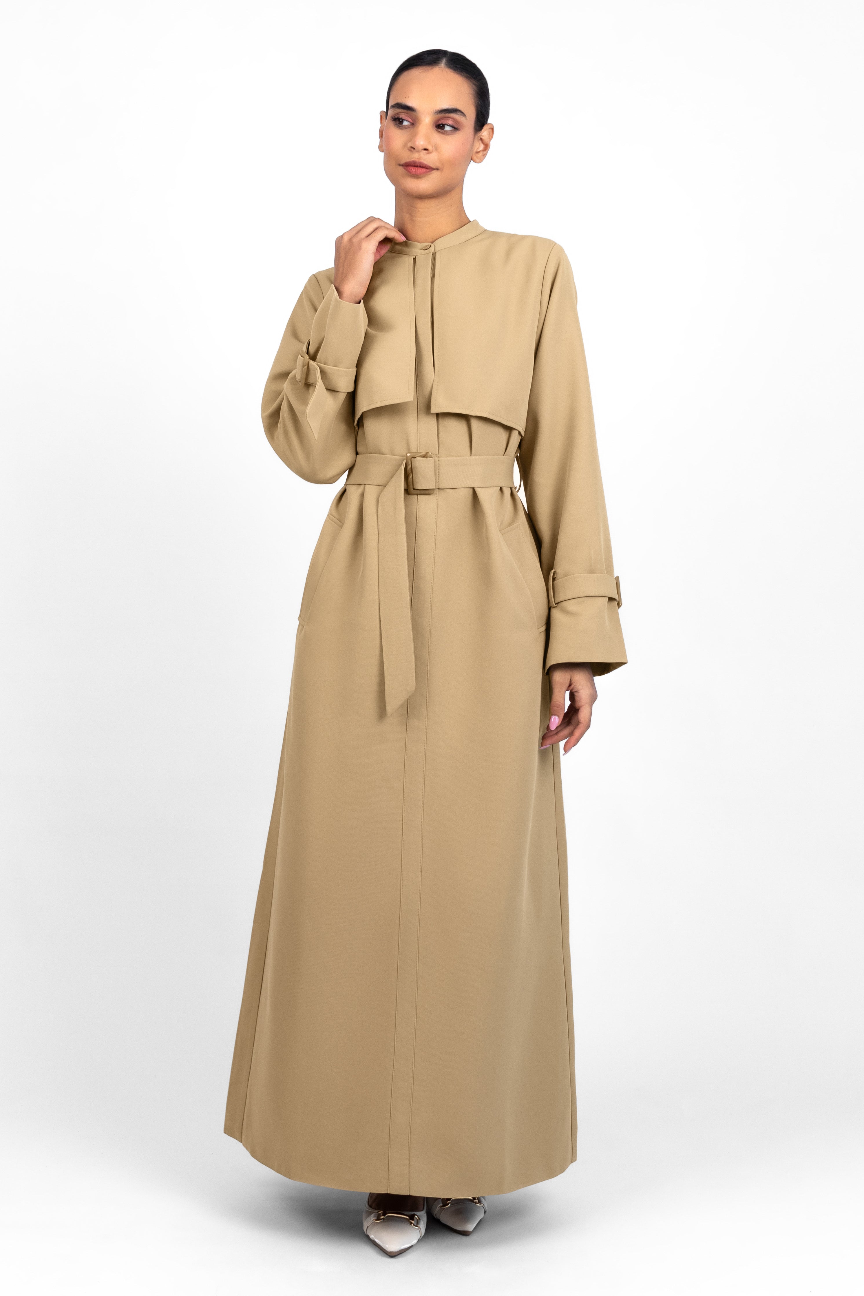 Colour: Tan. A girl standing in a Trench Coat Dress looking to the left.
