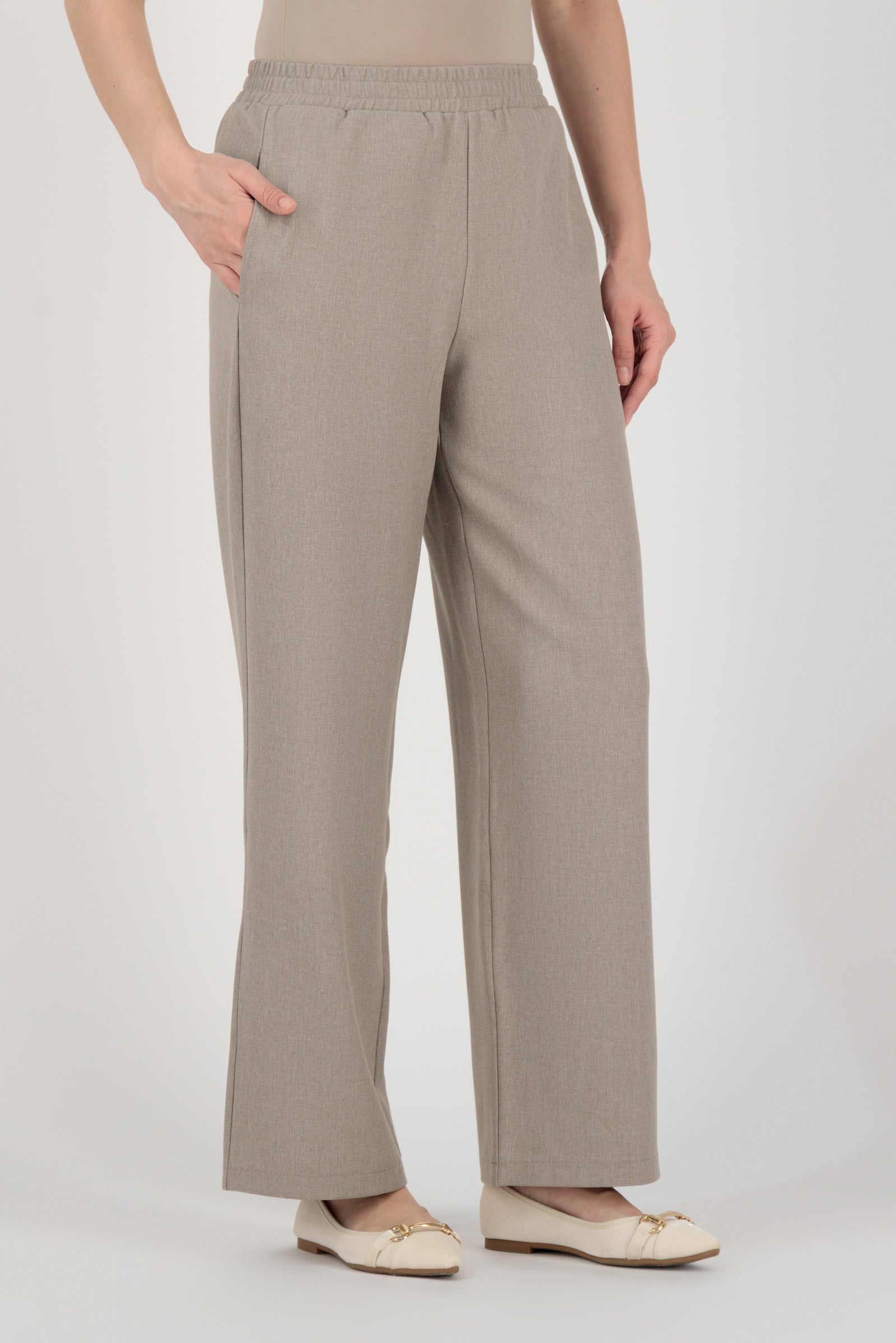 Angled back view of the FARES Tailored Elastic Waist Pants in Stone showing balanced proportions and softly tailored wide leg pants.