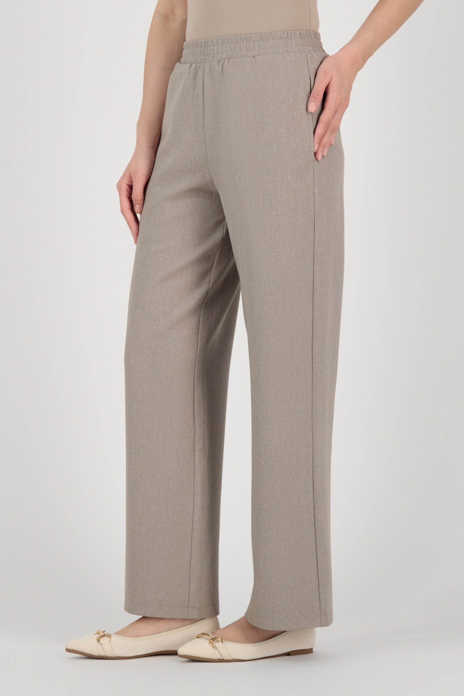 Side angle of the FARES Tailored Elastic Waist Pants in Stone emphasizing fluid wide leg pants movement with a refined elastic waist fit.