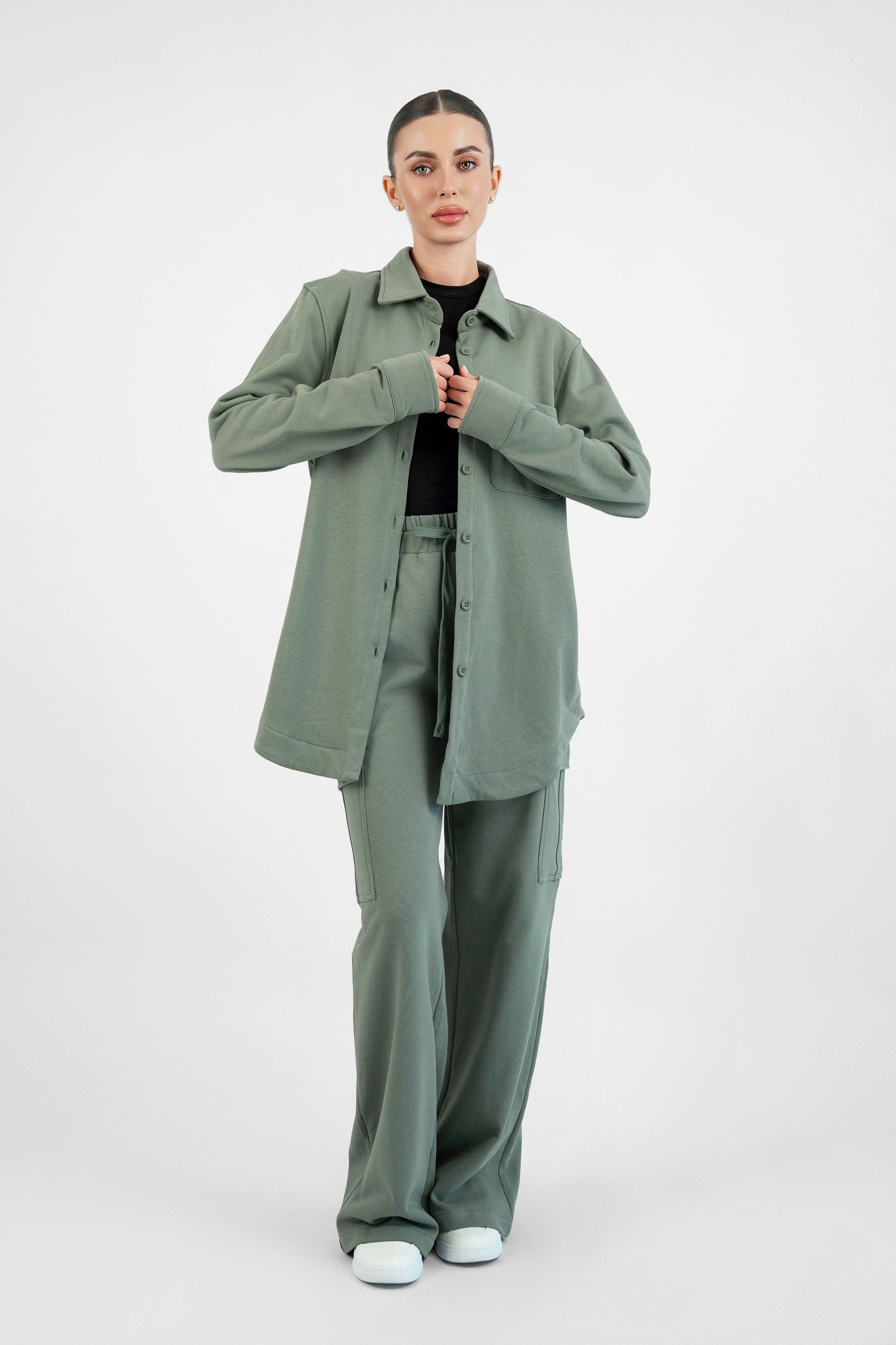 Colour: Oakmoss. A model in a front pose wearing an Oversized Cotton Shacket from FARES.
