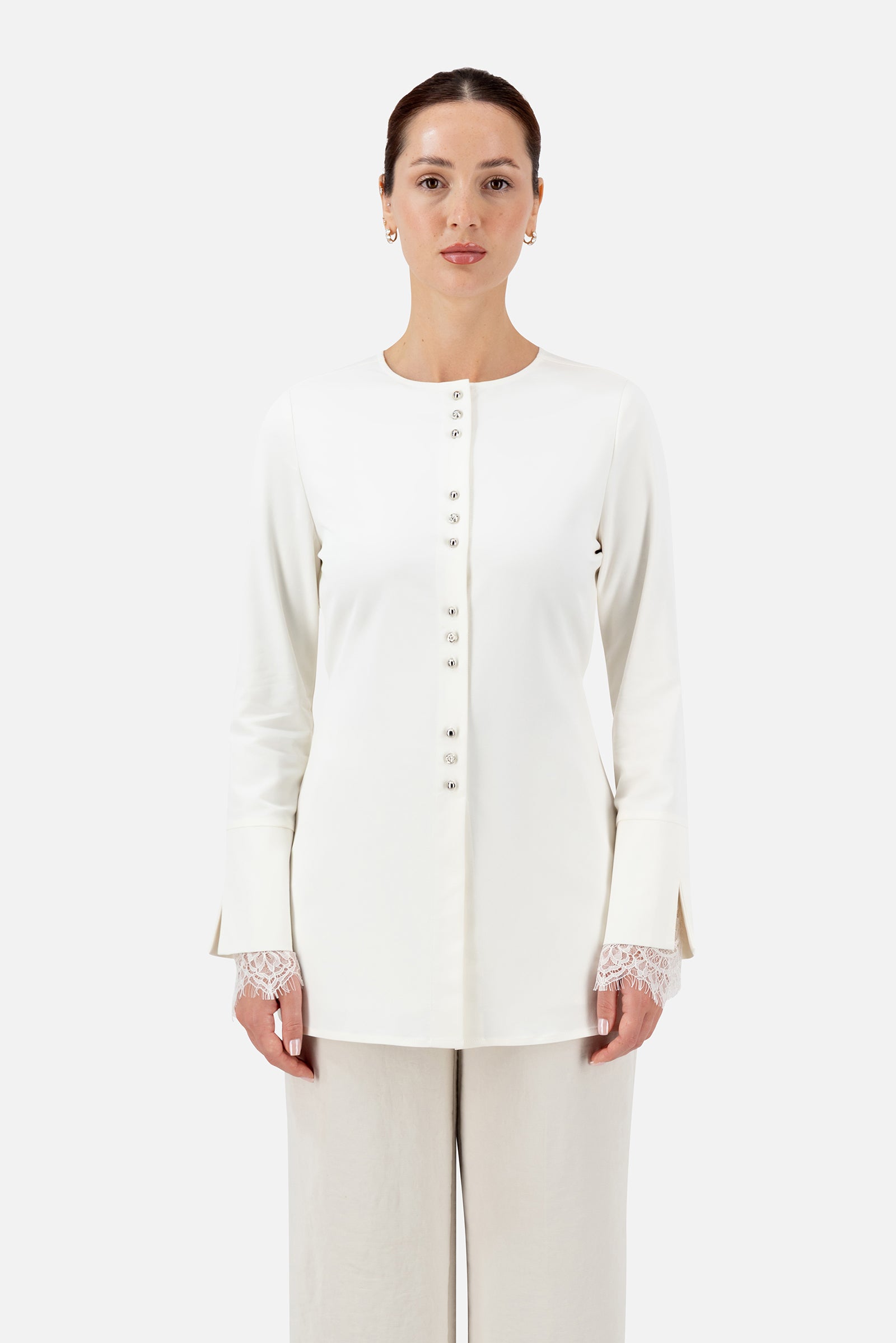 Woman standing in the Sugar button-up long-sleeve top with matching pants.