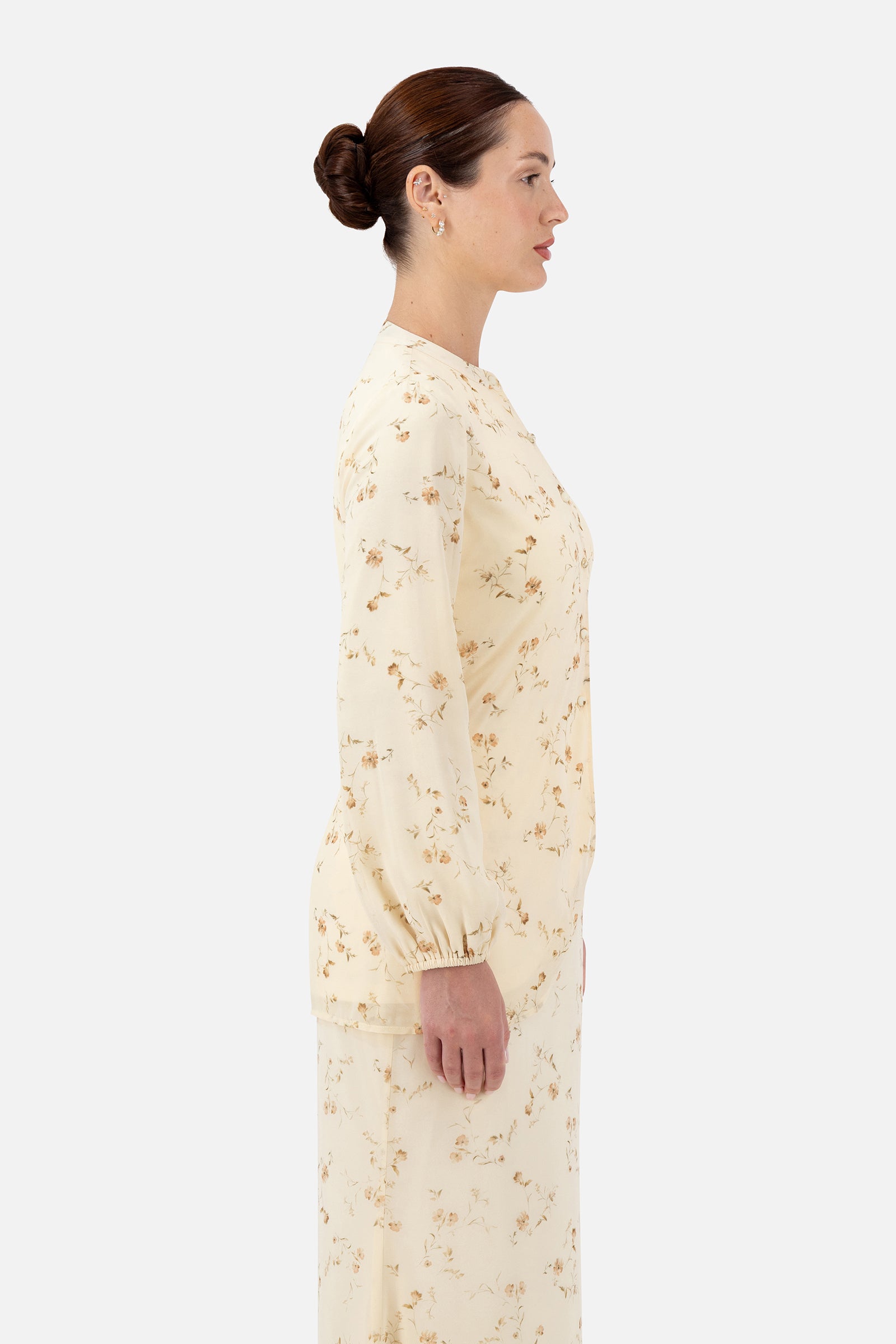 Side profile of the Butterbloom blouse highlighting the curved split hem and relaxed fit.