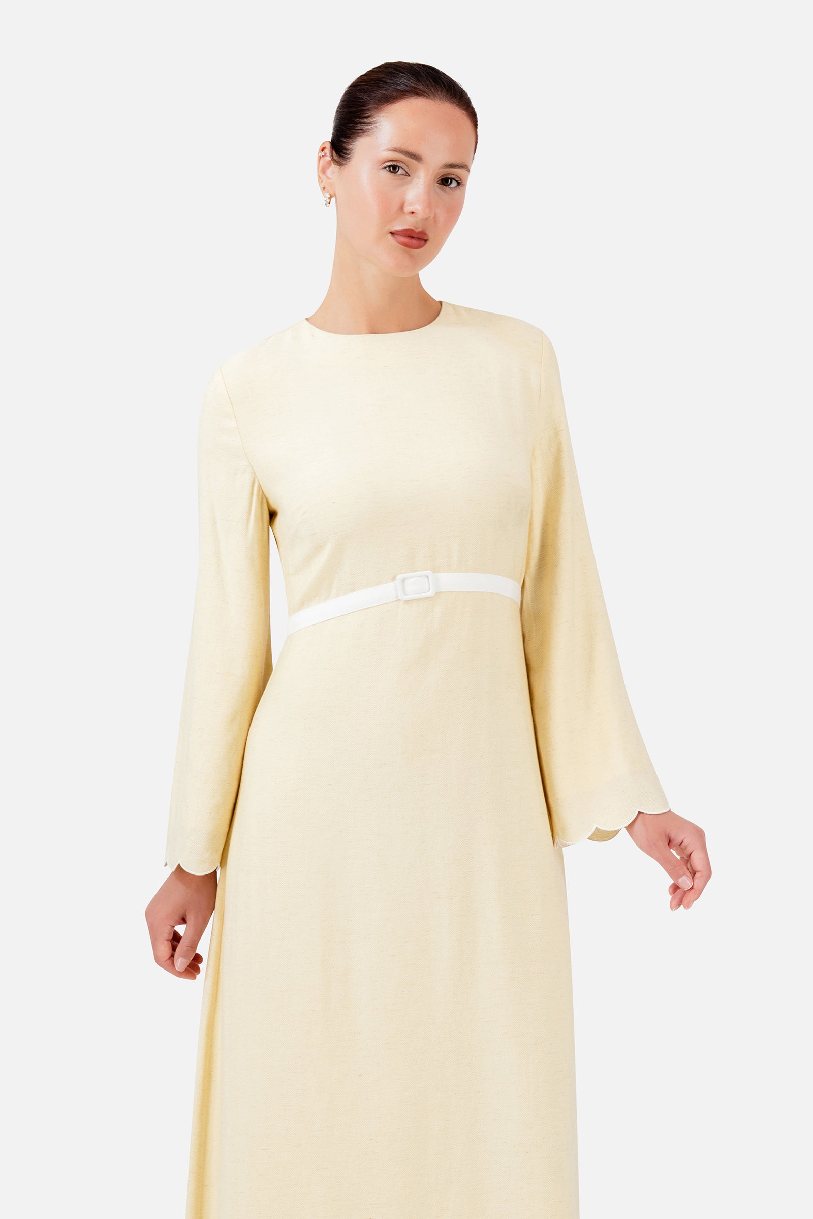 Closer view of the FARES Belt Detail Scalloped Dress in Buttercup, highlighting the scalloped neckline, long sleeves and slim belt.