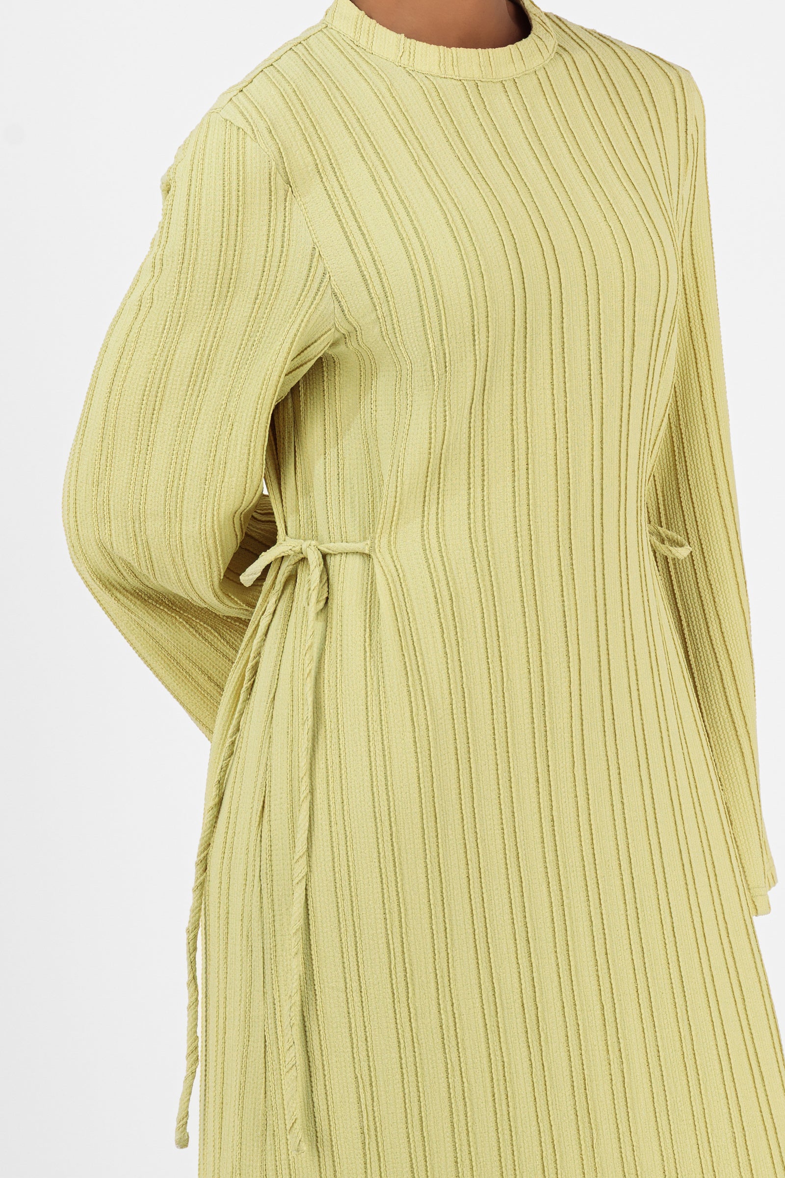 Close-up of the FARES Textured Bow Detail Dress in Lime highlighting the textured fabric and delicate waist tie details on the maxi dress.