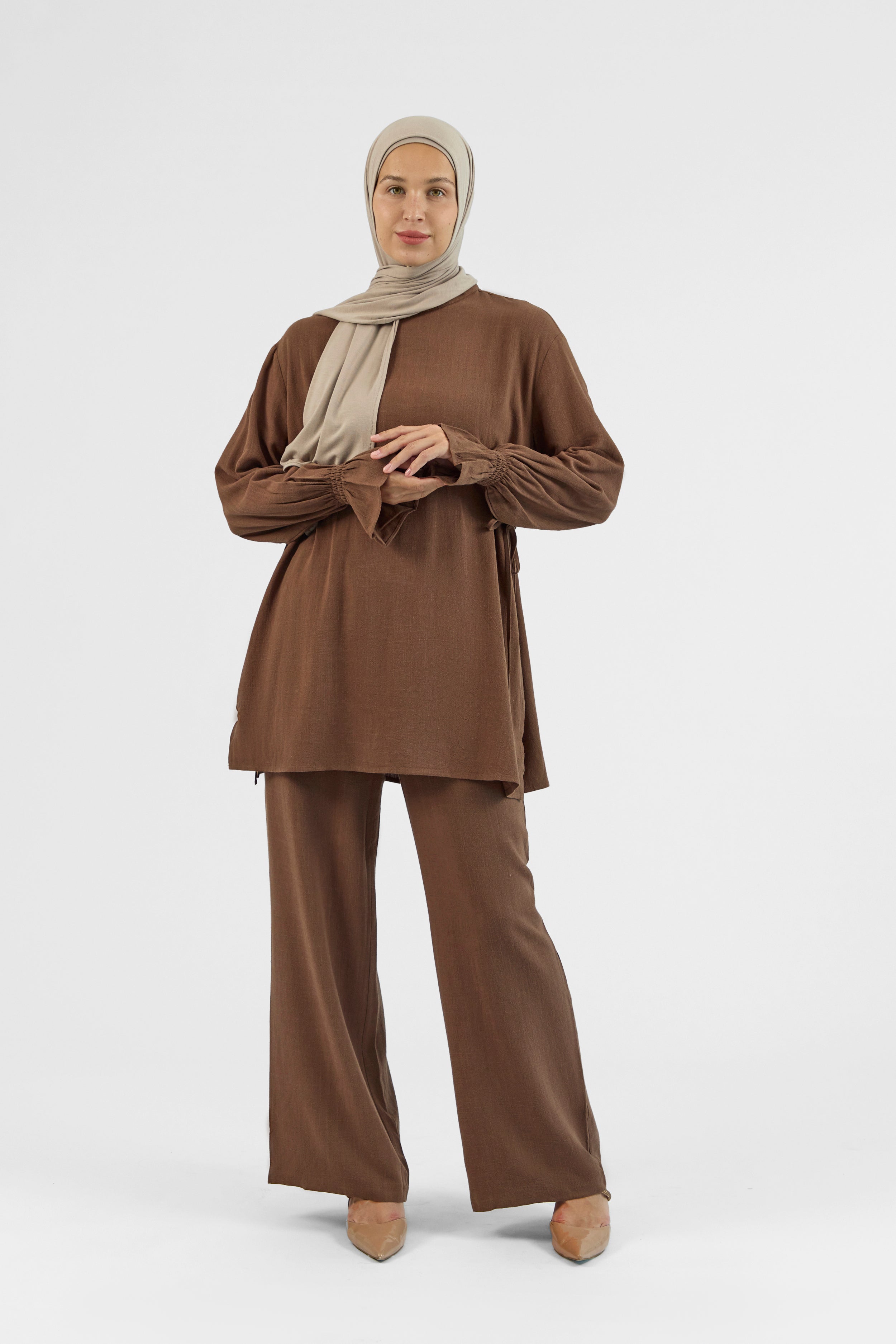 Colour: Chocolate. A model standing and looking to the left in a Bow Detail Linen Blend Top.