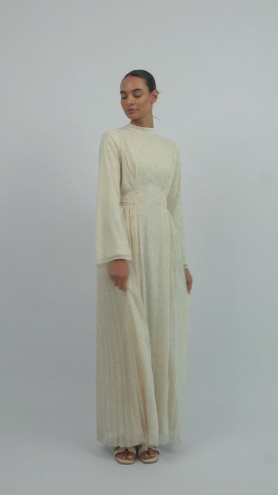Model walking in the FARES Printed Tie Dress with Pleats, showing the graceful movement and flowing pleats of the printed dress.