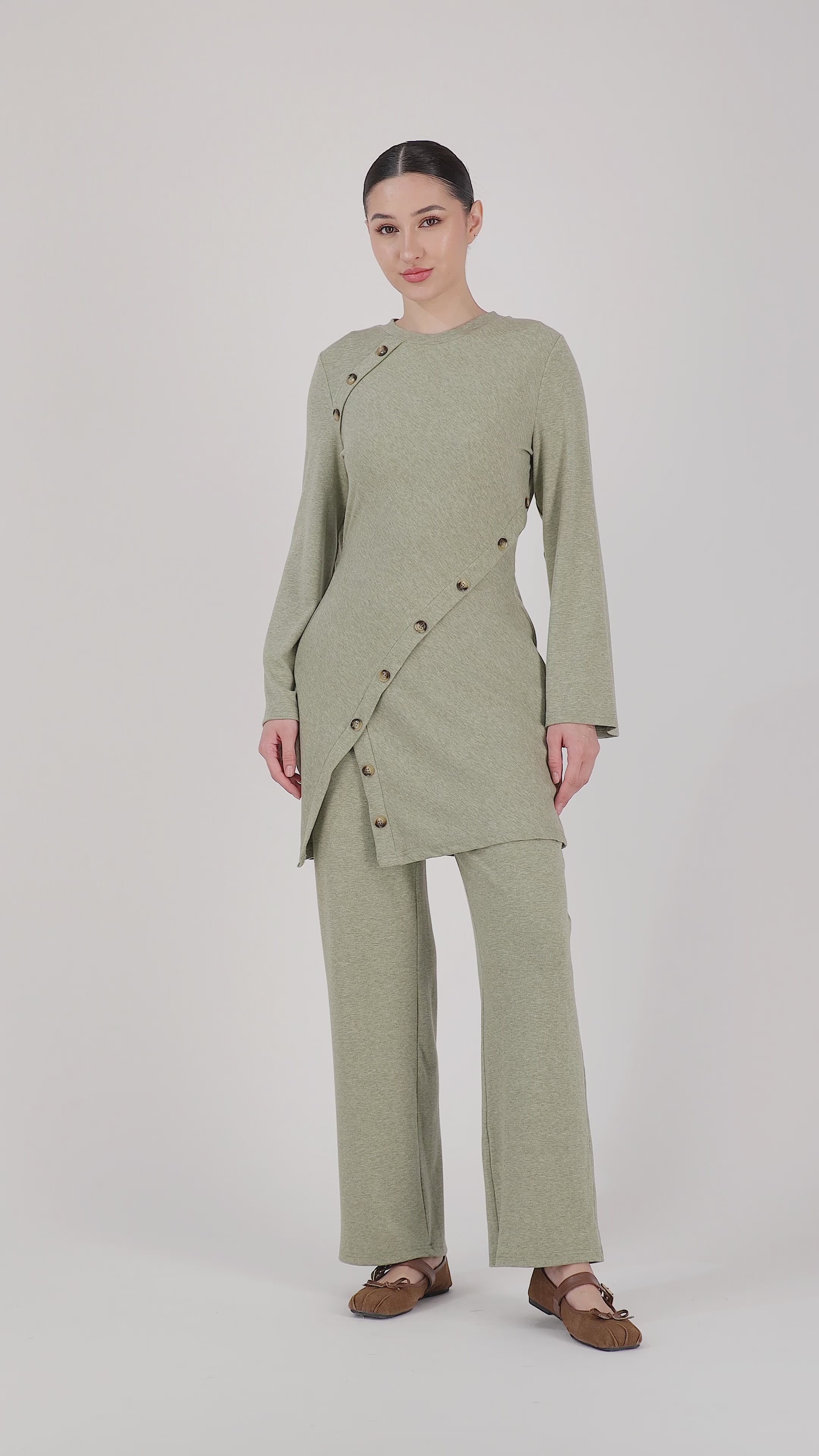 A model presents the FARES Straight Leg Knit Pants in Olive through natural movement, highlighting the comfort, drape, and softness of these knit pants.