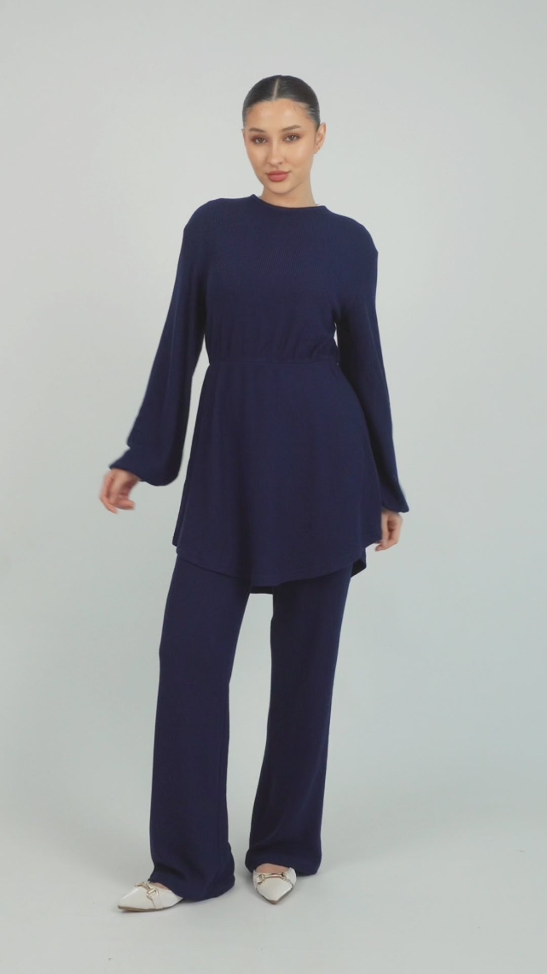 A model is showing poses in a Knit Peplum Top.	Colour: Navy