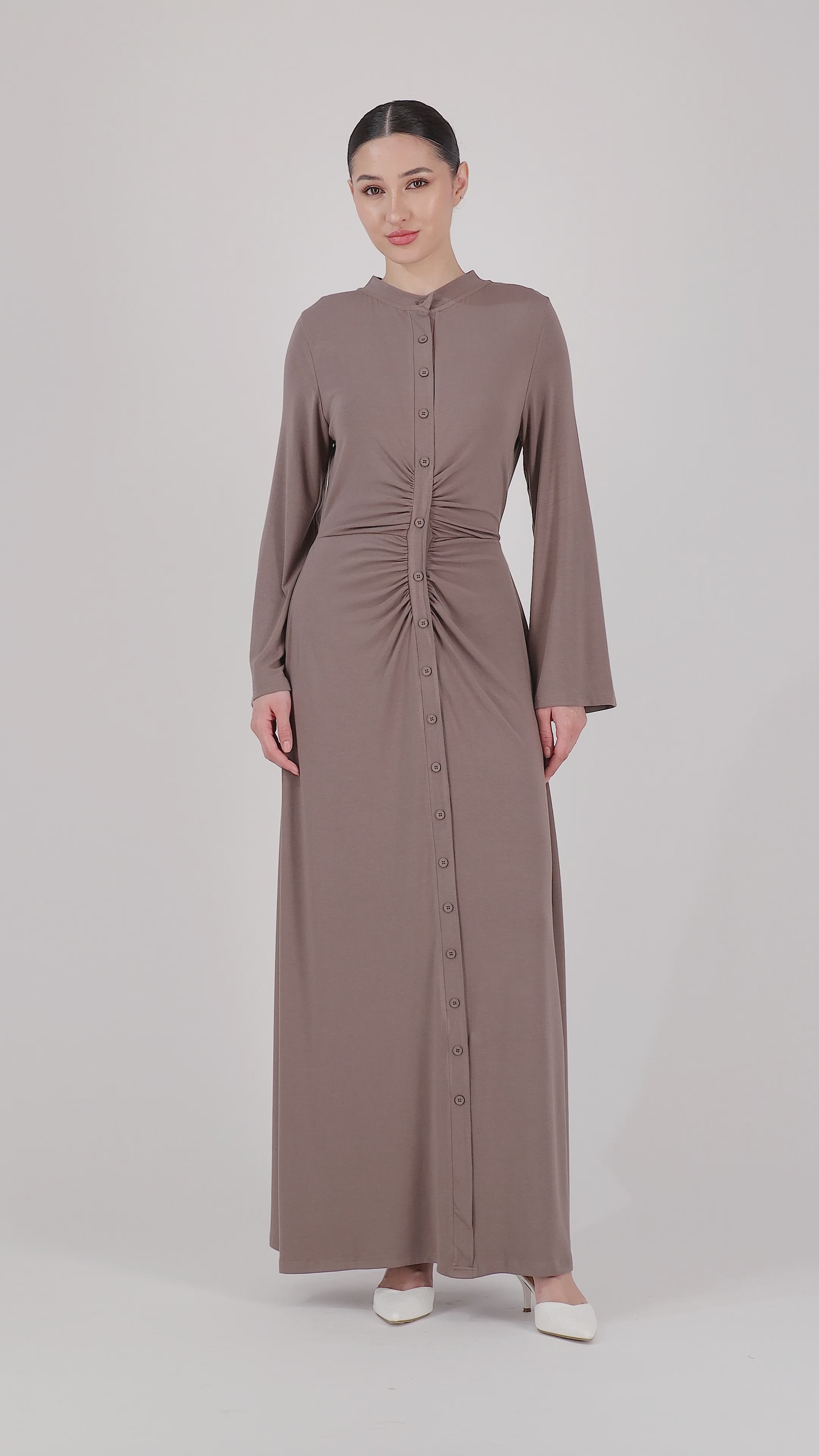 A model presents the FARES Gathered Waist Knit Dress in Pebble through fluid movement, showcasing the softness, fit, and elegant drape of this knit dress.