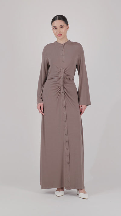 A model presents the FARES Gathered Waist Knit Dress in Pebble through fluid movement, showcasing the softness, fit, and elegant drape of this knit dress.