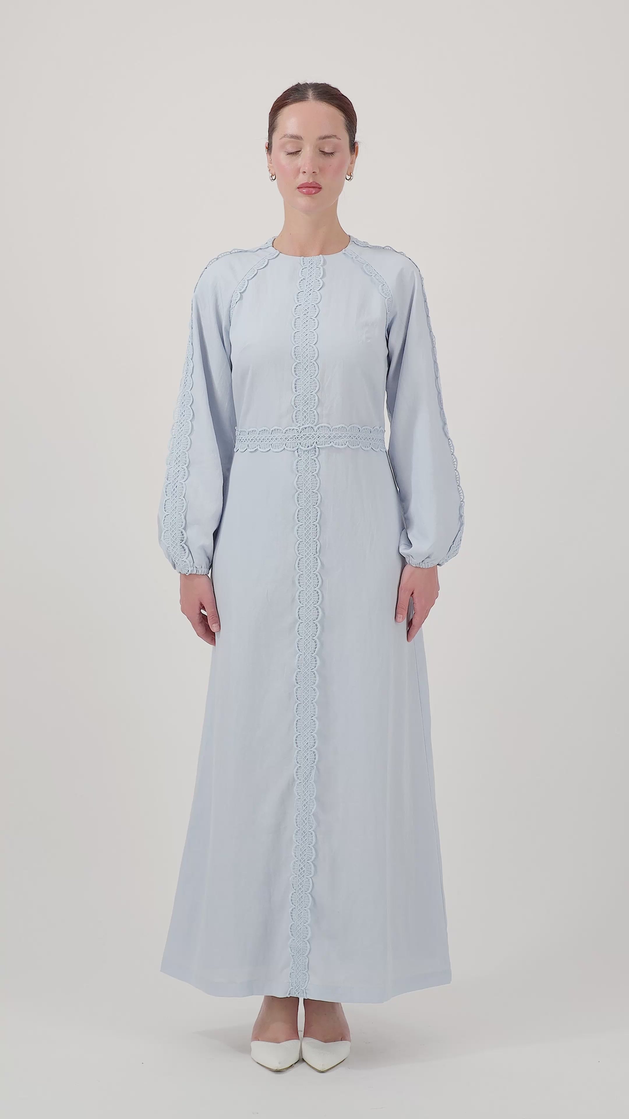 Model walking while wearing the Bluebell Crochet Trim Maxi Dress, showcasing its elegant movement.