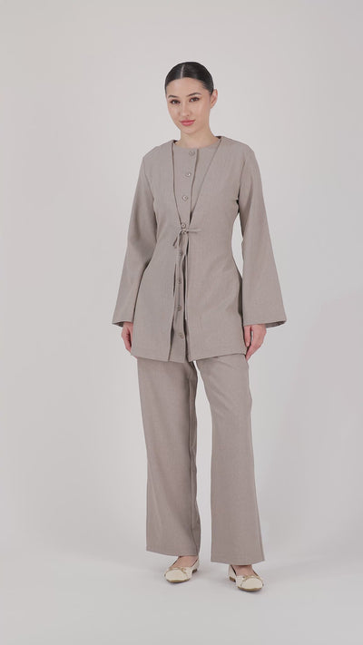 A model walks naturally in the FARES Tailored Elastic Waist Pants in Stone, showcasing the flow, comfort and relaxed movement of these wide leg elastic waist pants.