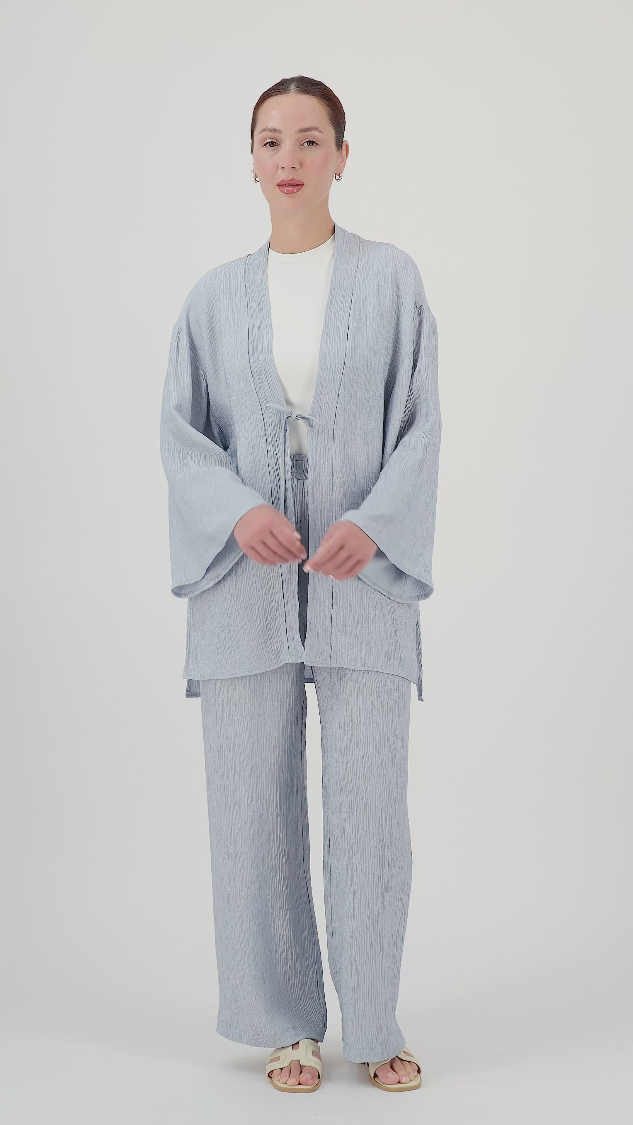 Model walks, turns from side to side and showcases the Icy Blue rippled relaxed fit pants in motion.
