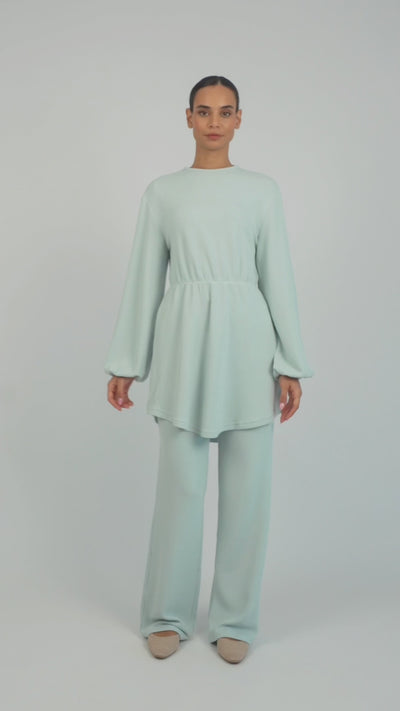 A model is showing poses in a Knit Peplum Top.	Colour: Icy: Blue