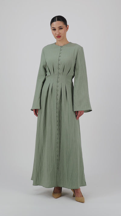 Video of a model walking in the FARES Tailored Waist Button Front Dress in Clover showcasing the elegant movement of the maxi dress.