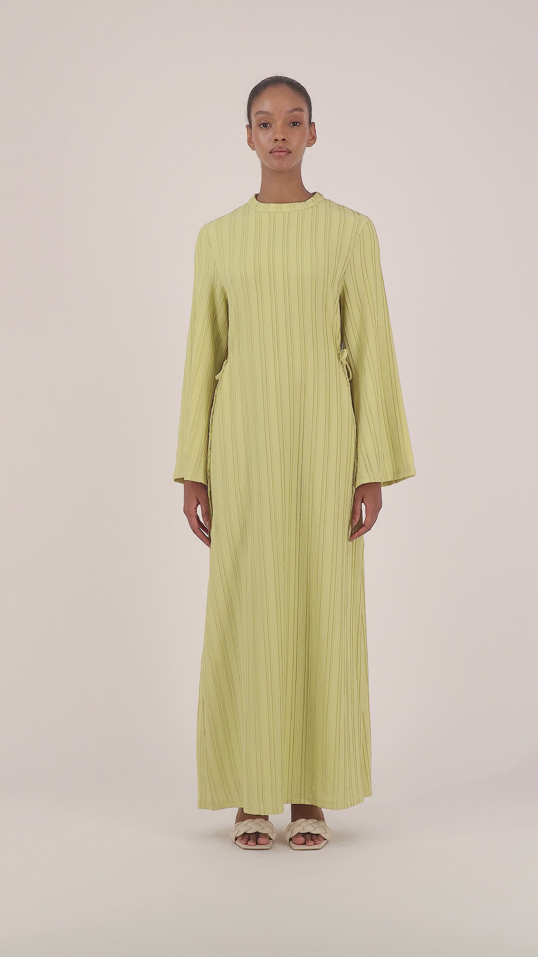Video of a model walking in the lime FARES long sleeve maxi dress showcasing the fluid silhouette and elegant movement.