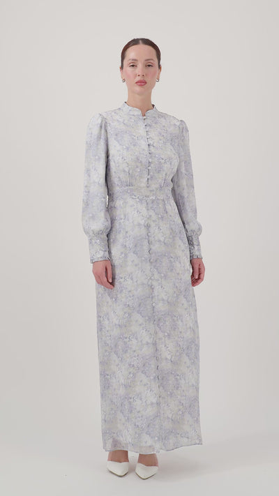 Model walking while wearing the Blue Dreams Printed Vintage Detail Dress, showcasing its elegant movement.