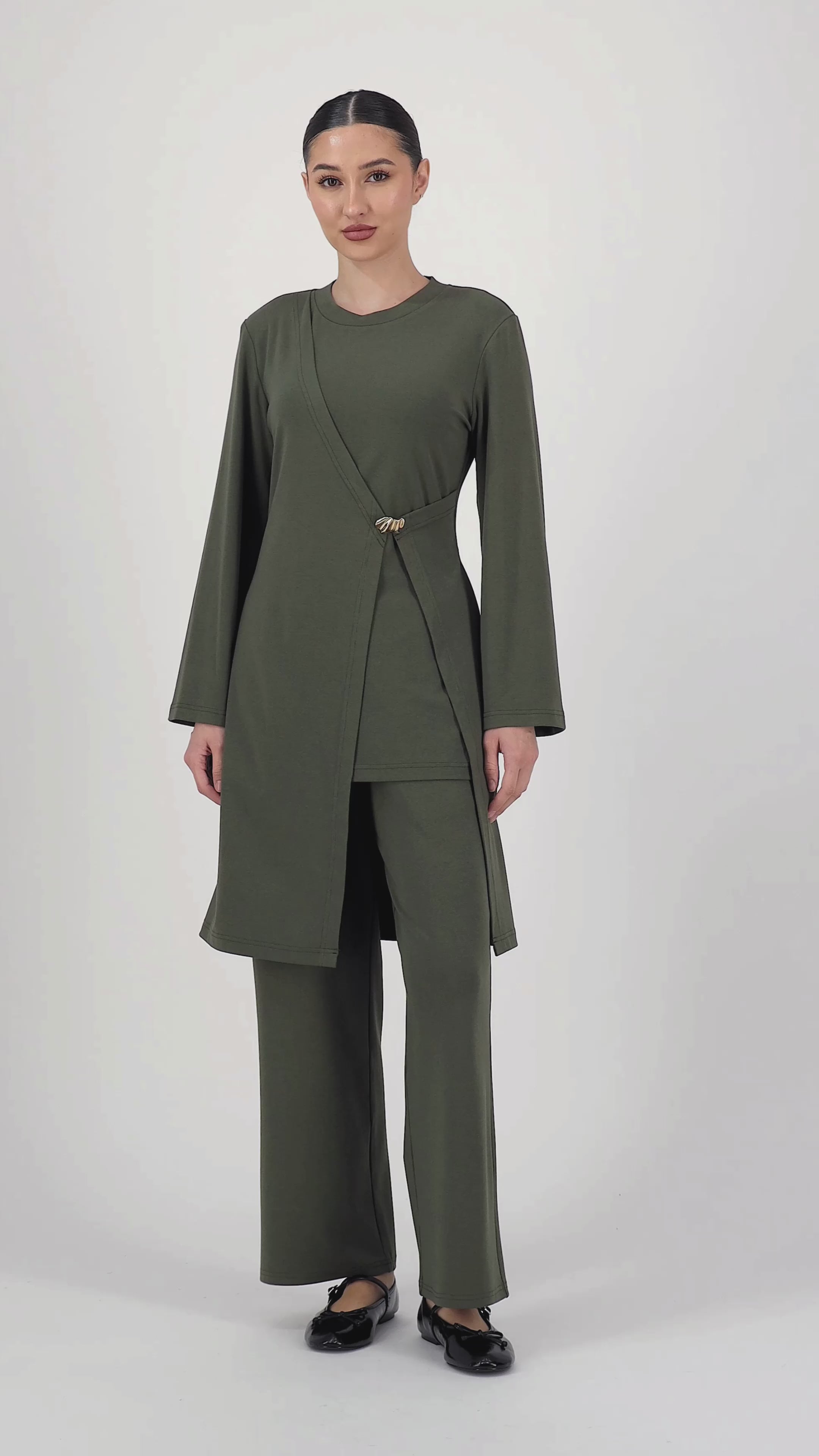 Video of the model moving in the Gold Accent Wrap Top Evergreen, highlighting the flattering wrap shape and graceful sleeve line of this long sleeve wrap top.