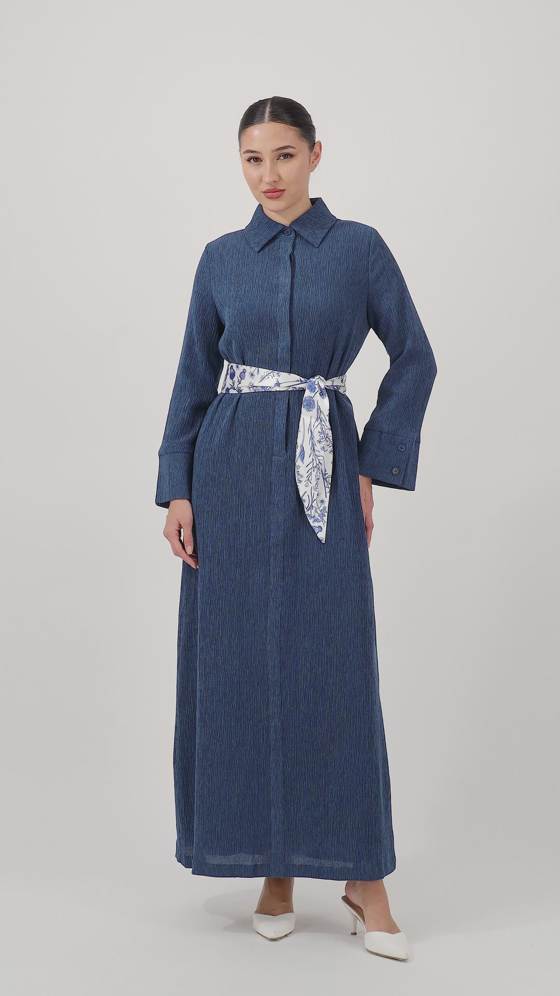 Model walks, turns from side to side and showcases the Indigo Printed Satin Belt Dress in motion.