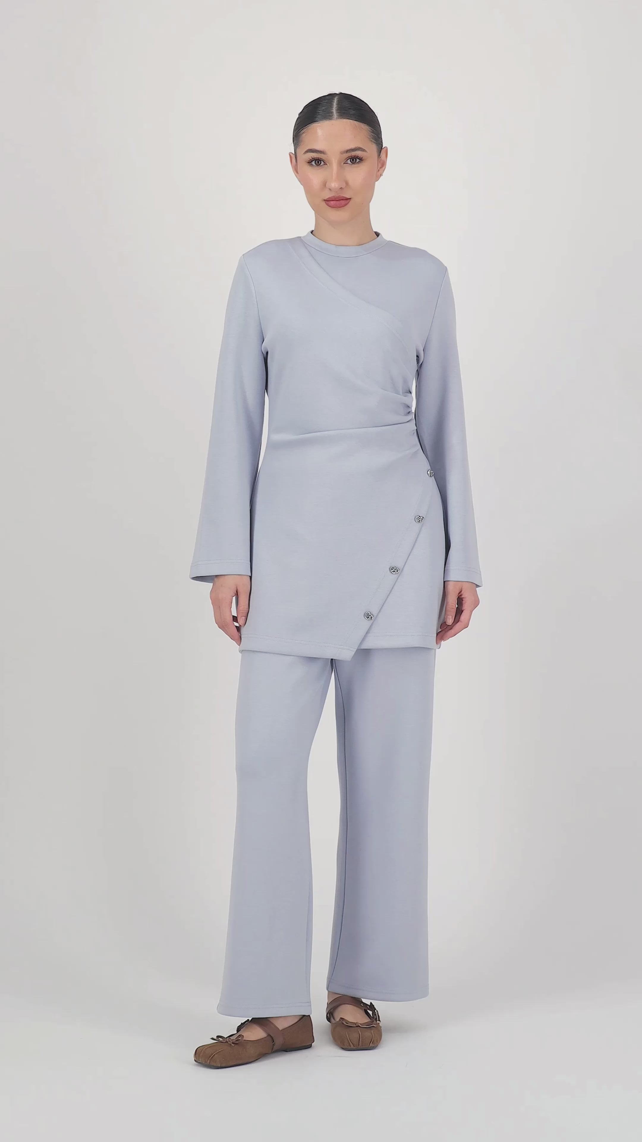 Short video of the model moving naturally in the Buttery Side Ruched Tunic Bluebell, showcasing the flattering ruched detail, soft stretch fabric, and how effortlessly this piece fits into tunic tops styling.