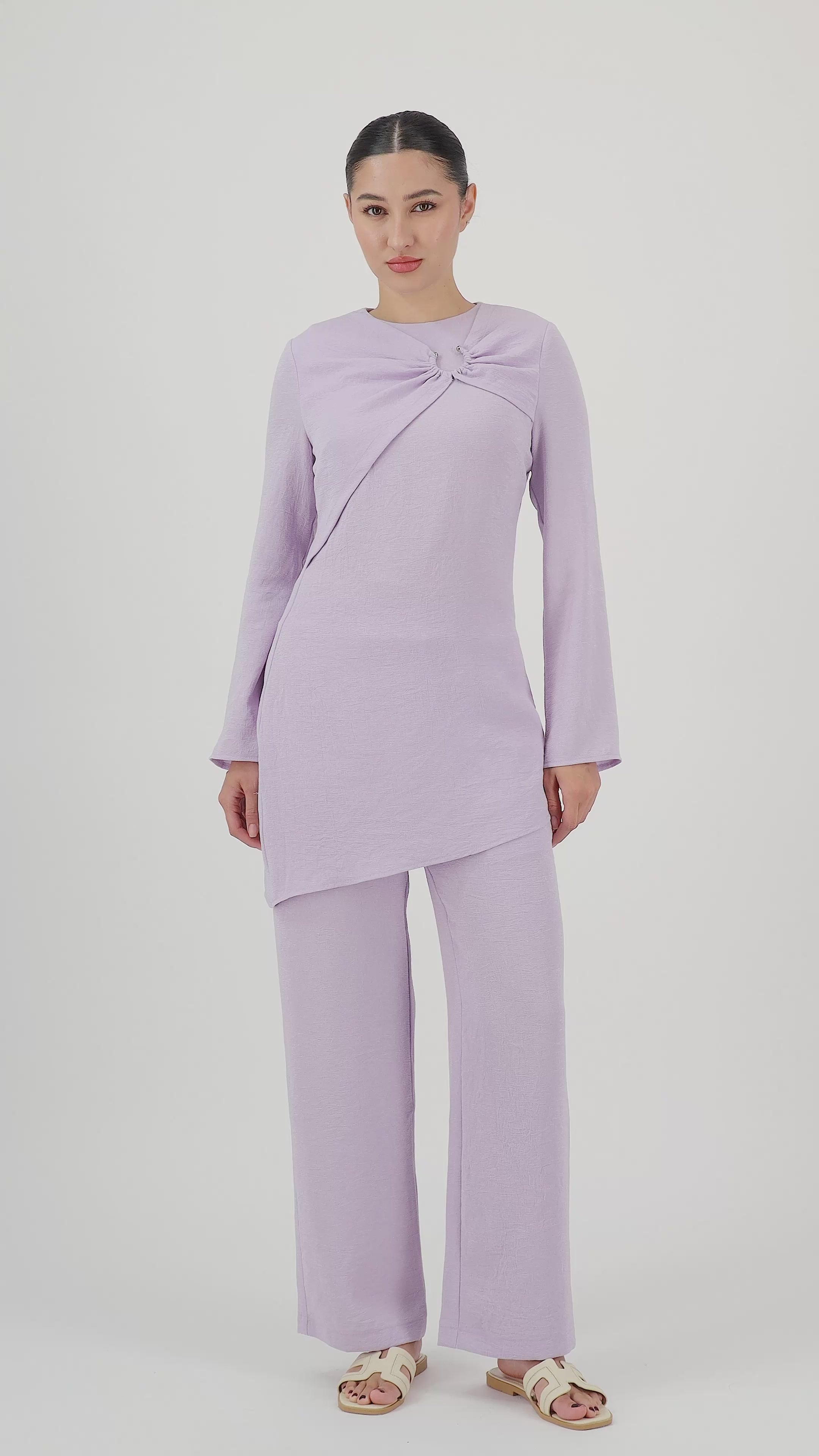 Model walks, turns from side to side and showcases the Lilac relaxed fit pants in motion.