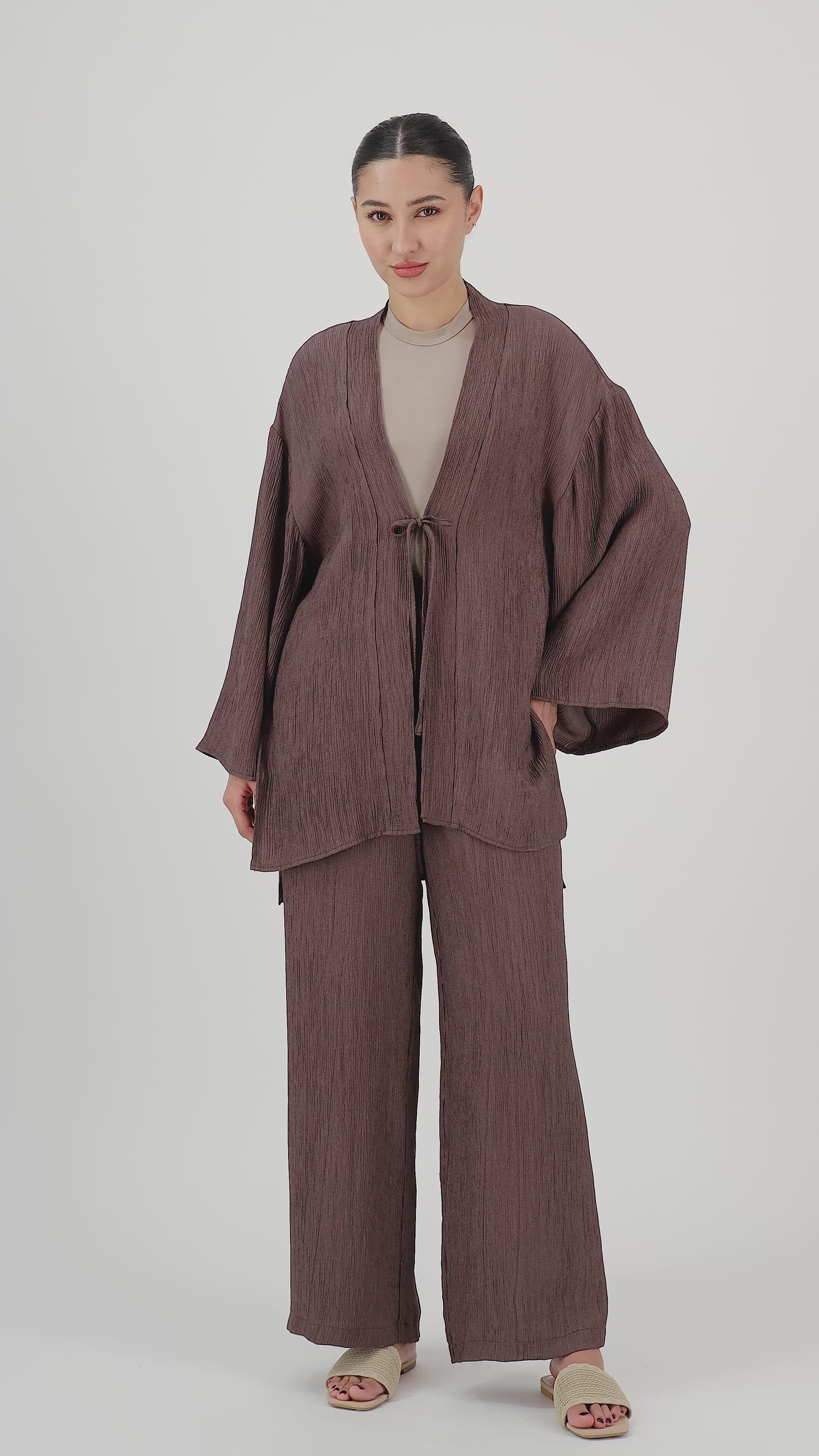 Model walks, turns from side to side and showcases the Icy Brown rippled relaxed fit pants in motion.