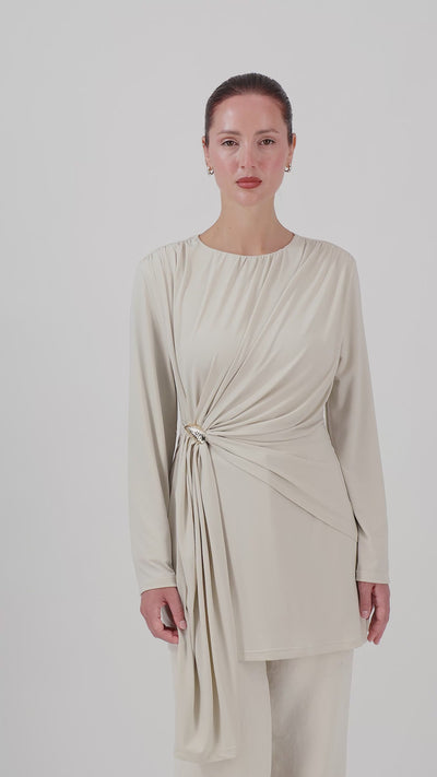 A woman walks in the FARES Side Draped Tunic in Vanilla Cream, showing the natural movement of the draped fabric and flowing tunic silhouette.