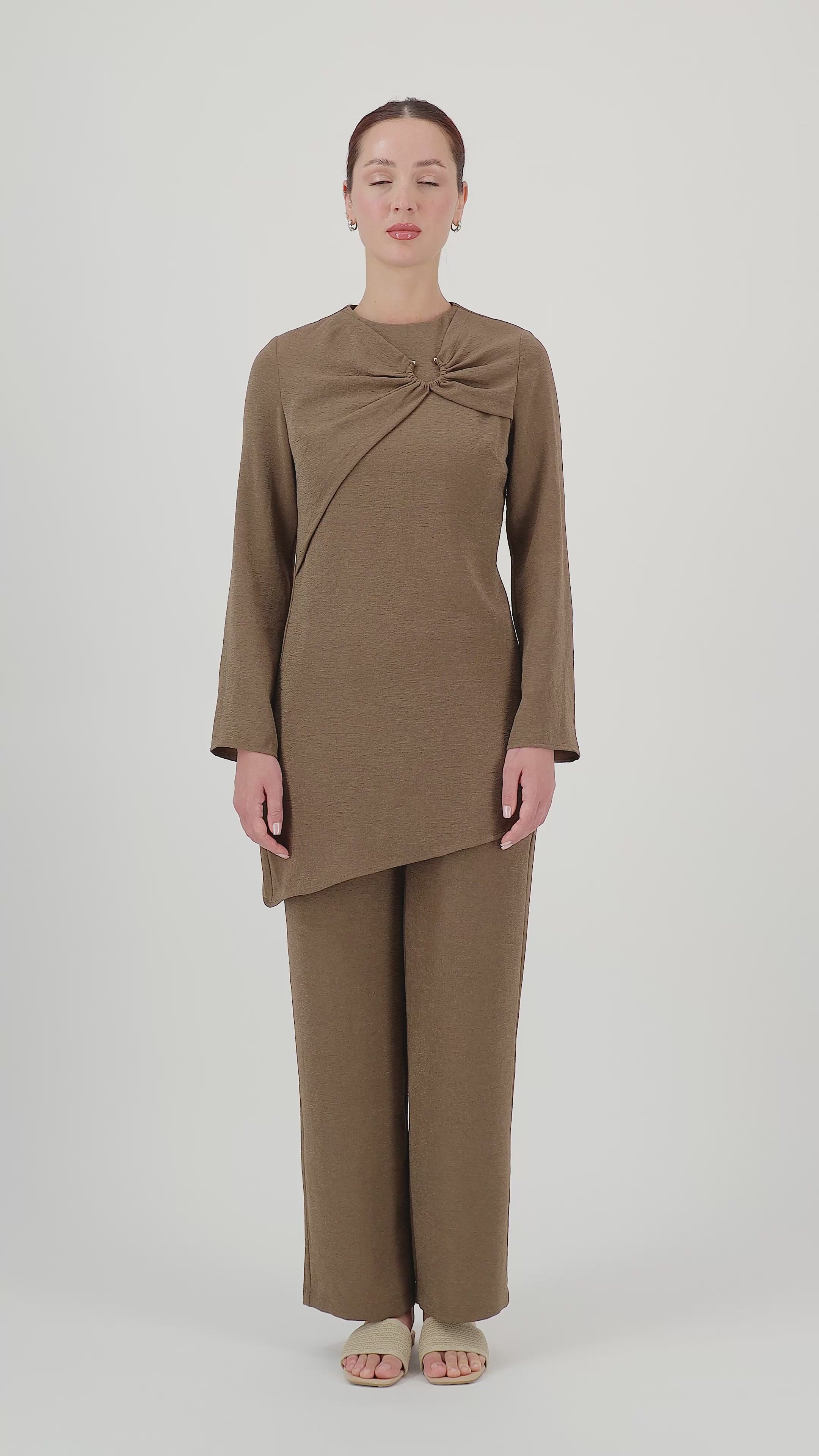 Model walks, turns from side to side and showcases the Espresso relaxed fit pants in motion.